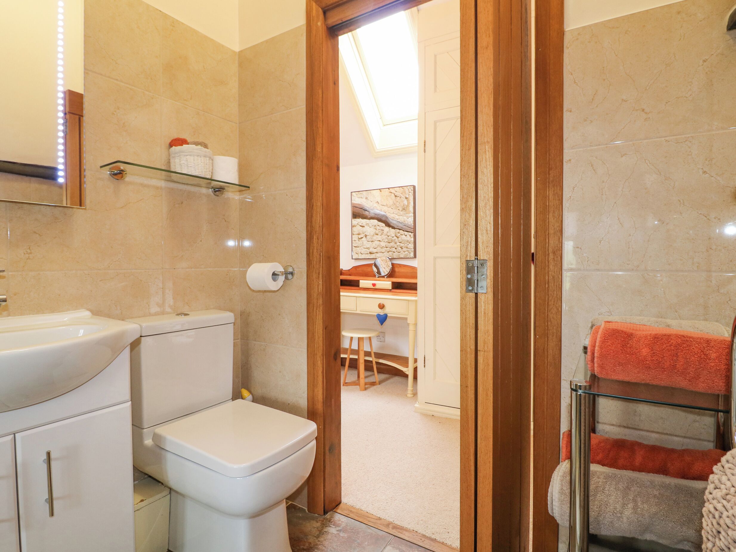 Un baño con inodoro, lavamanos y zona de ducha.