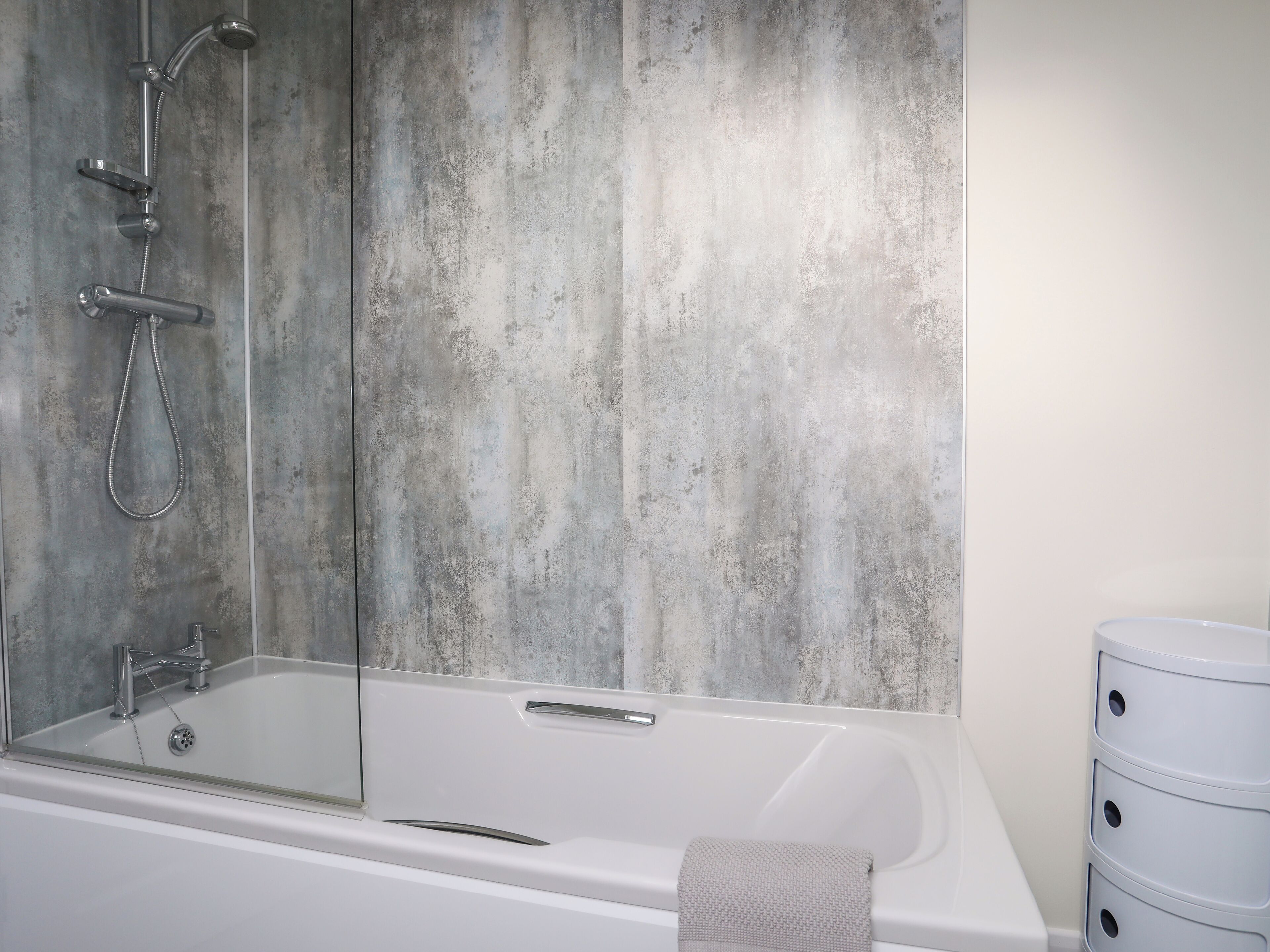 Ein modernes Badezimmer mit Badewanne, Dusche und einem großen Spiegel.