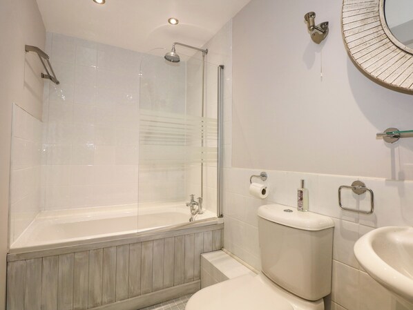 A modern bathroom with a glass-enclosed shower, a freestanding bathtub, a toilet, and a sink. - Swyn Llyr (Rhosneigr)