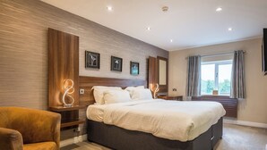 Un dormitorio moderno con una cama grande, una pared decorativa de madera y una ventana con cortinas.