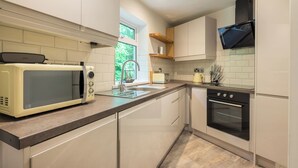 Una cocina moderna con armarios blancos, microondas, tostadora y horno.
