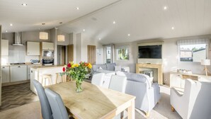 Un amplio salón con mesa de comedor, sofás y televisor.