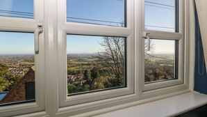 Ein Fenster mit Blick auf eine Stadt und die umliegende Landschaft.