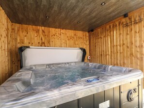 A hot tub in a wooden room with a ceiling and a wall-mounted hook. - 163 Manchester Road (Accrington)
