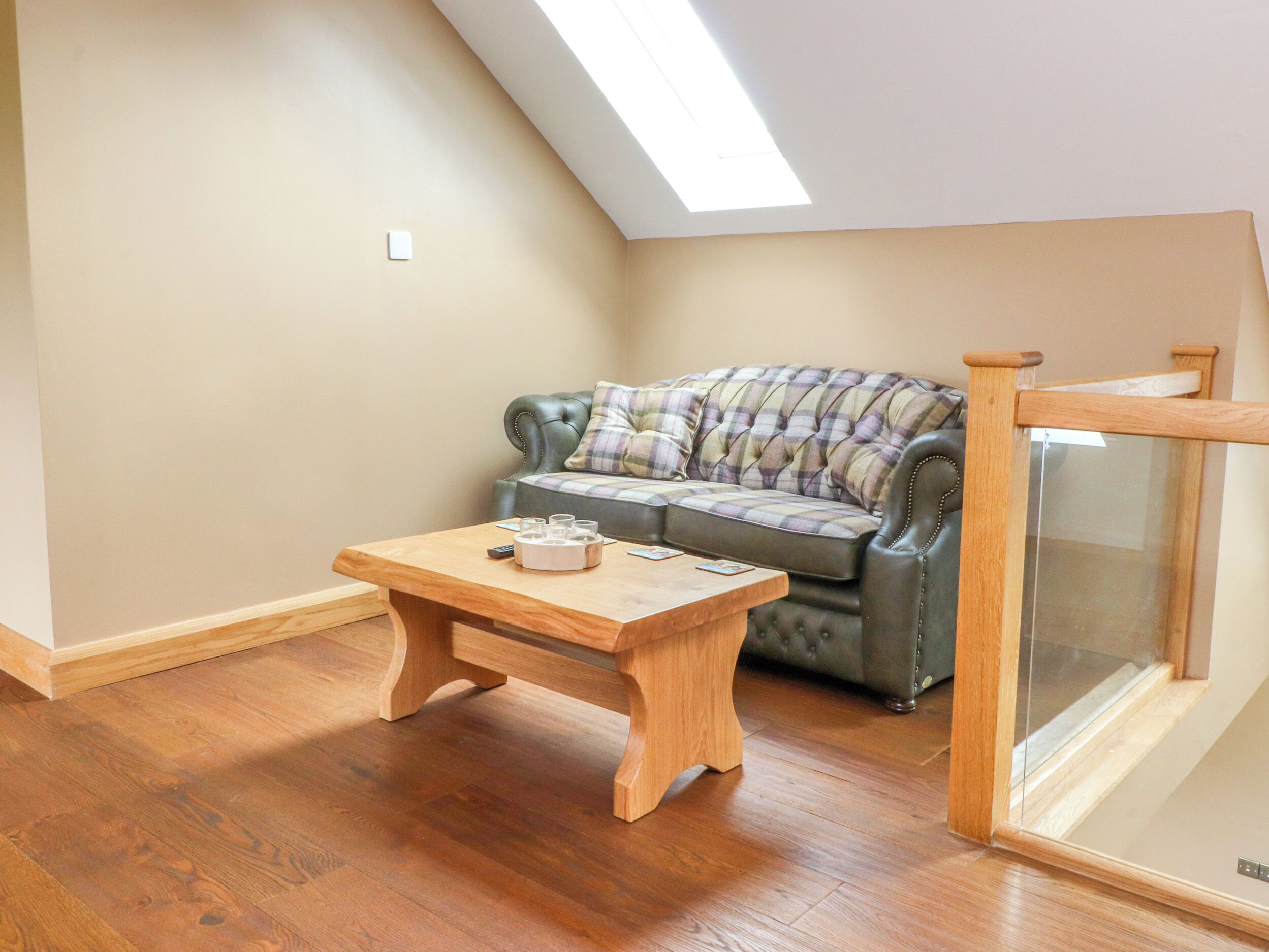 Una habitación acogedora con una mesa de madera, un sofá con cojines y un ventanal de vidrio.