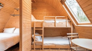 Une cabane confortable avec un lit en mezzanine, un lit superposé en bas et une petite table.
