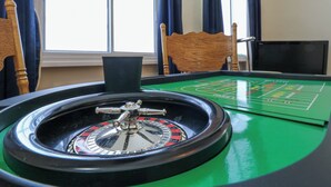 Un tavolo da roulette con un panno verde, una ruota che gira e una ruota della fortuna.