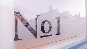 Una ventana con un diseño de vidrio esmerilado que muestra el texto "No1" y "ALOJAMIENTO DE CLASE | NUMBERONECLARE.CO.UK".