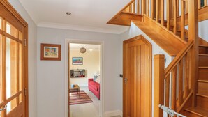 A hallway with wooden doors and a staircase. - Llain Gwynfor (Haverfordwest)