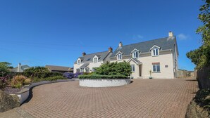 A large, two-story house with a paved driveway and a landscaped garden. - Llain Gwynfor (Haverfordwest)