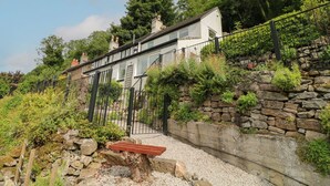 A row of terraced houses with a stone retaining wall and a metal fence. - Roseville (Matlock)