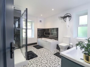 Une salle de bain moderne avec une douche à parois de verre, une baignoire sur pieds et des toilettes.