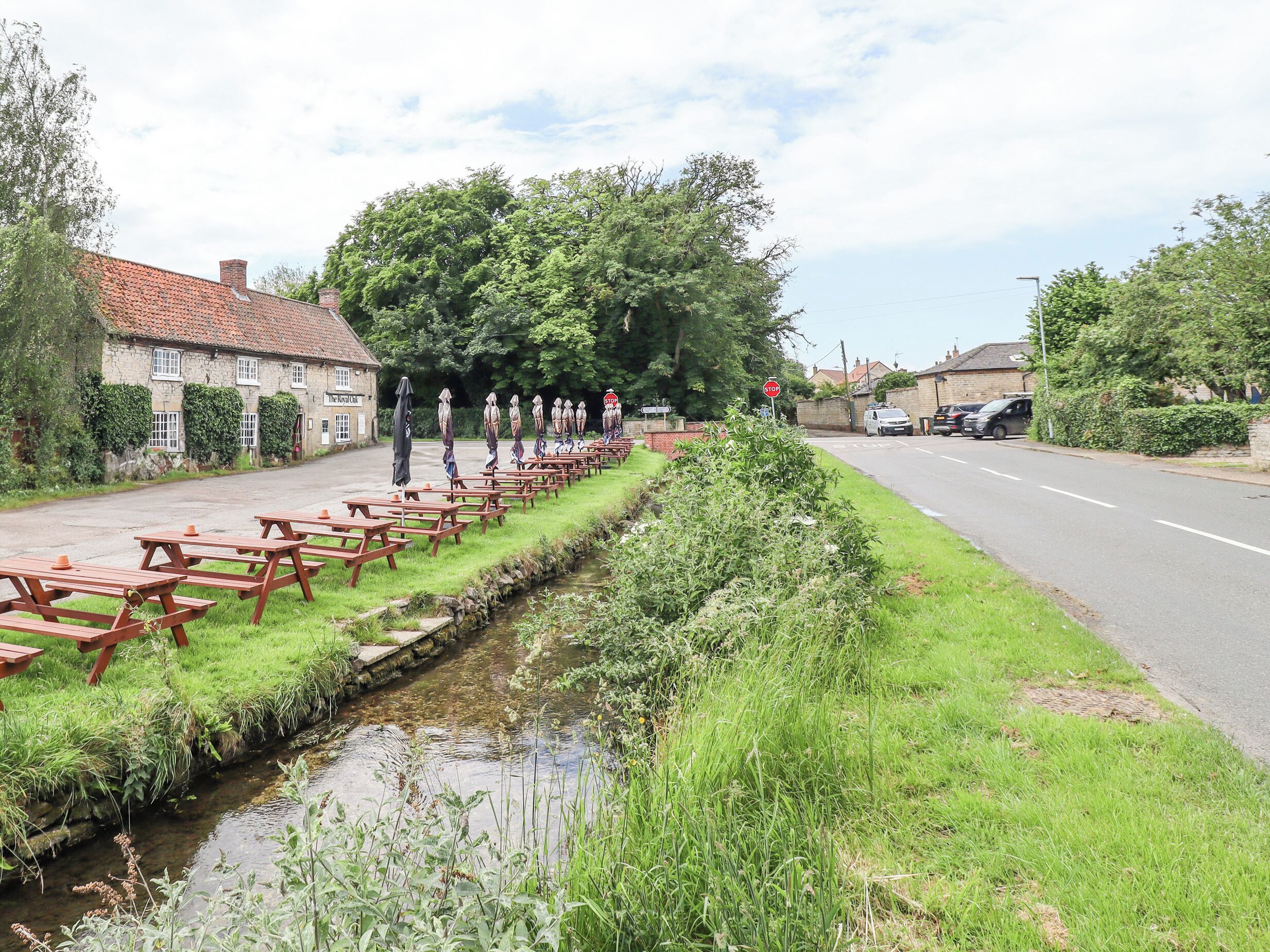 A riverside picnic area with benches and a small stream.