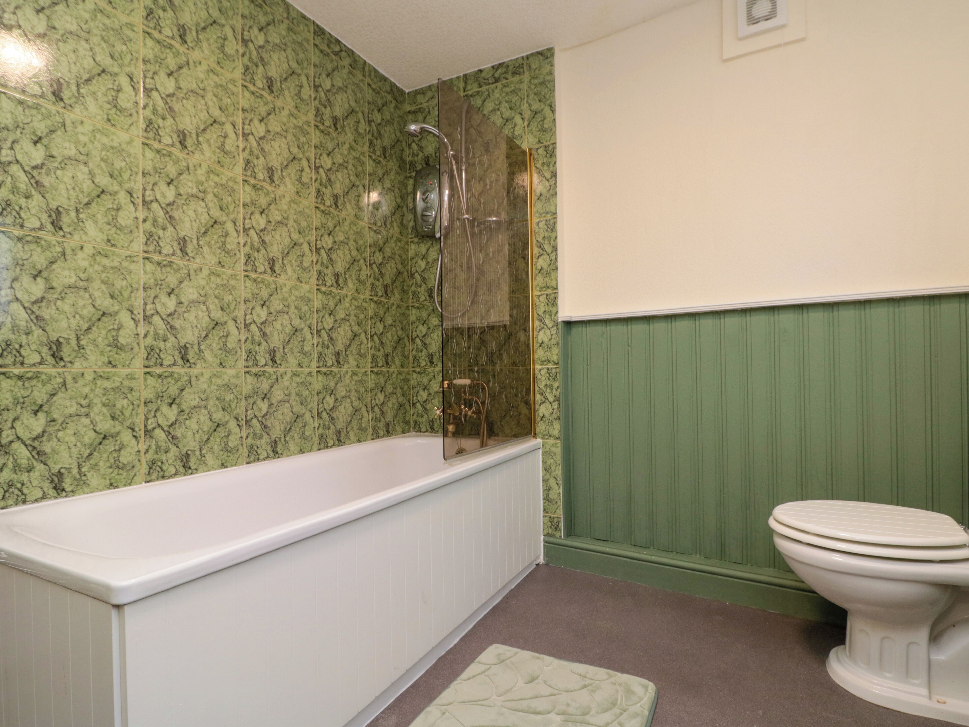 A bathroom with a bathtub, shower, and toilet.