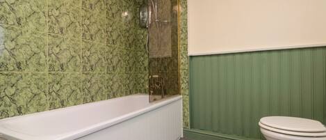 A bathroom with a bathtub, shower, and toilet.