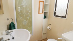 A bathroom with a sink, toilet, and a shower with a glass door. - Upper Calffield Caravan (Haverfordwest)