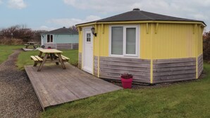 A yellow and grey mobile home with a small porch and a picnic table. - Hartland Quay (Bideford)