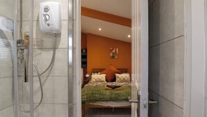 A bathroom with a shower, a toilet, and a sink. - Duck Tavern Annexe (Rhosgoch)