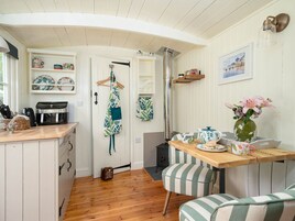 A cozy kitchen with wooden cabinets, a coffee machine, and a hanging apron.