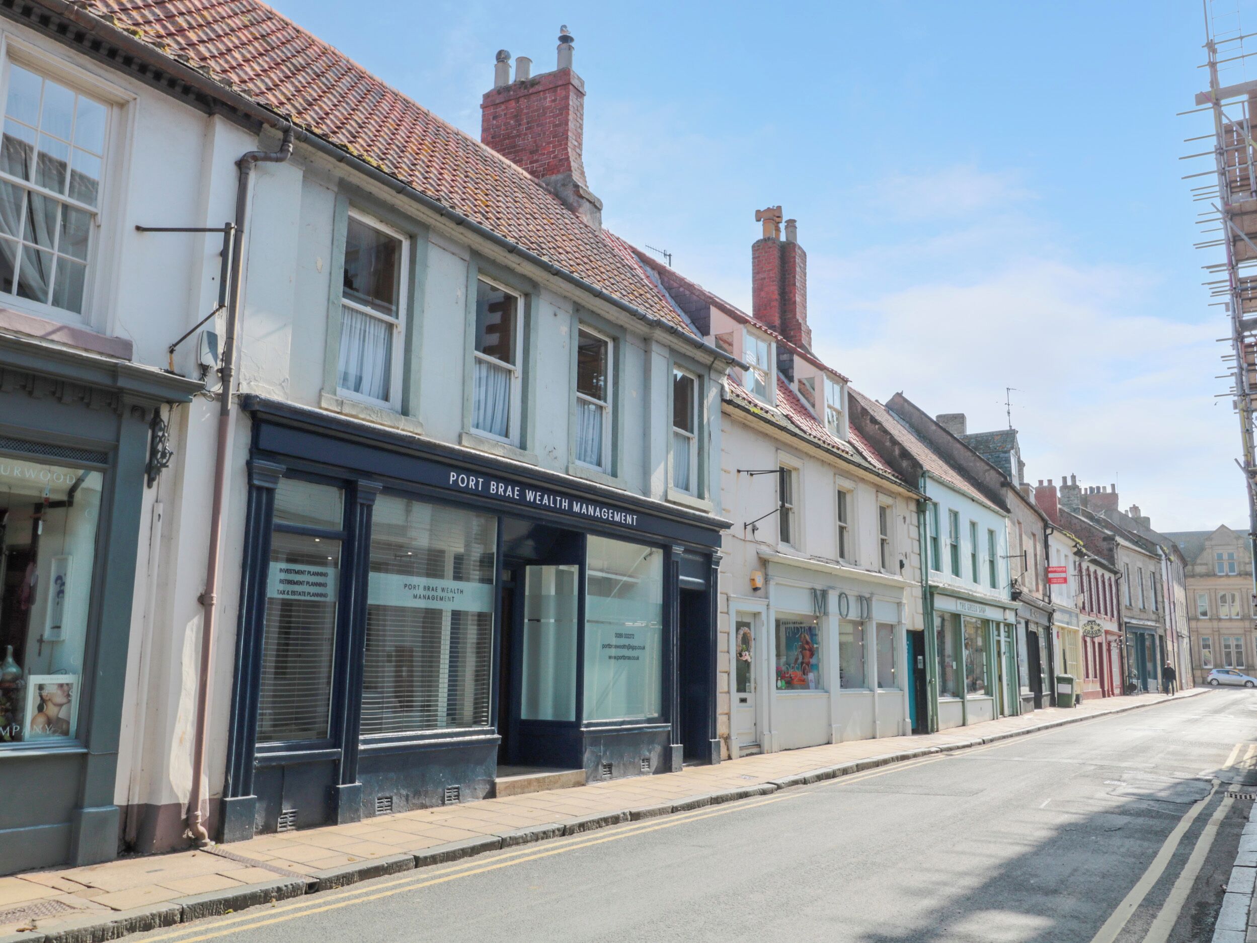 Une rue bordée d’immeubles, dont les bureaux de Port Brae Wealth Management.