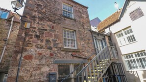 A stone building with a staircase leading to a door marked "50C". - The Old Factory House (Berwick-upon-Tweed)