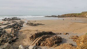 A beach with rocky formations and a sandy shore. - Badgers Sett (Bude)
