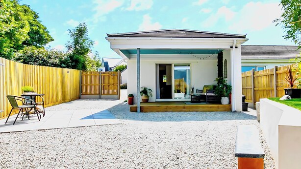 A covered patio area with a seating arrangement and a small table. - The Studio (Bude)