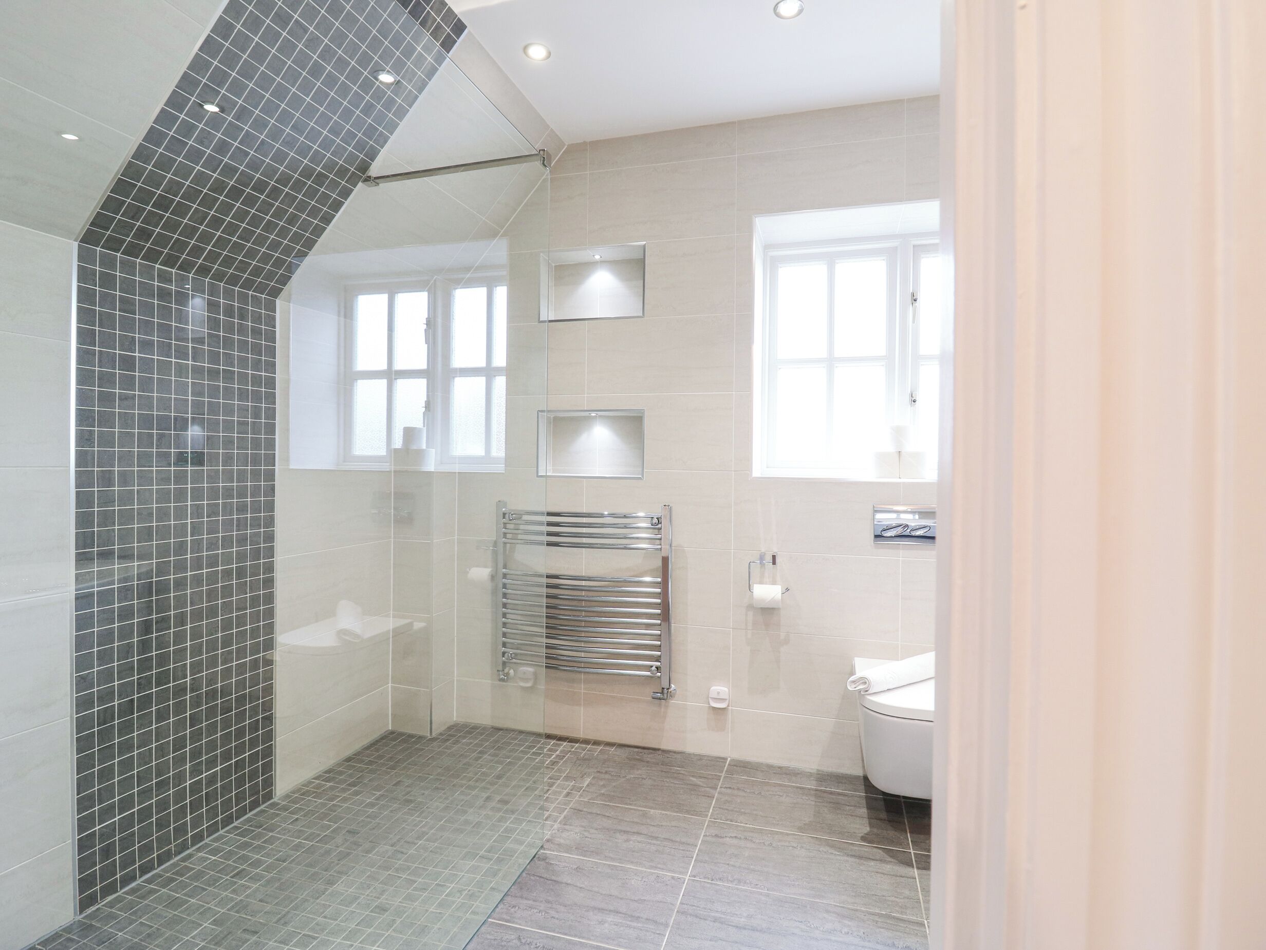 A modern bathroom with a shower, toilet, and a glass-enclosed shower area.