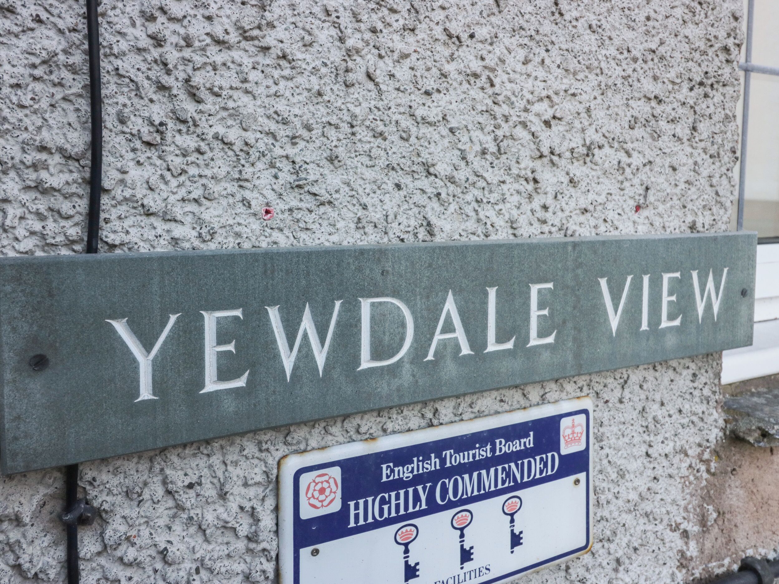 Un senyal de carrer per a 'Yewdale View' i un cartell que indica 'Instal·lacions recomanades per l'English Tourist Board'.