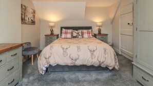 A bedroom with a bed, two bedside tables, a chair, a wardrobe, and a painting on the wall. - 15 High Street (Scarborough)
