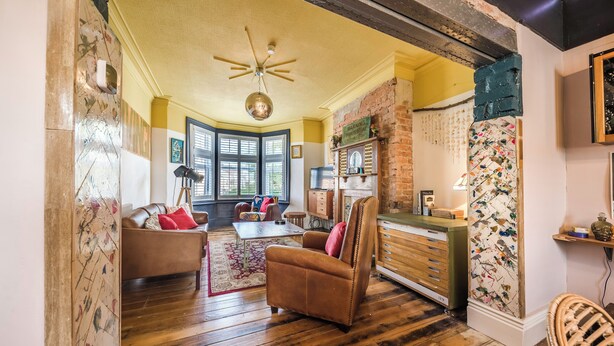 A spacious living room with a brown leather sofa, a wooden coffee table, and a brick accent wall. - Pats Palace (Whitley Bay)