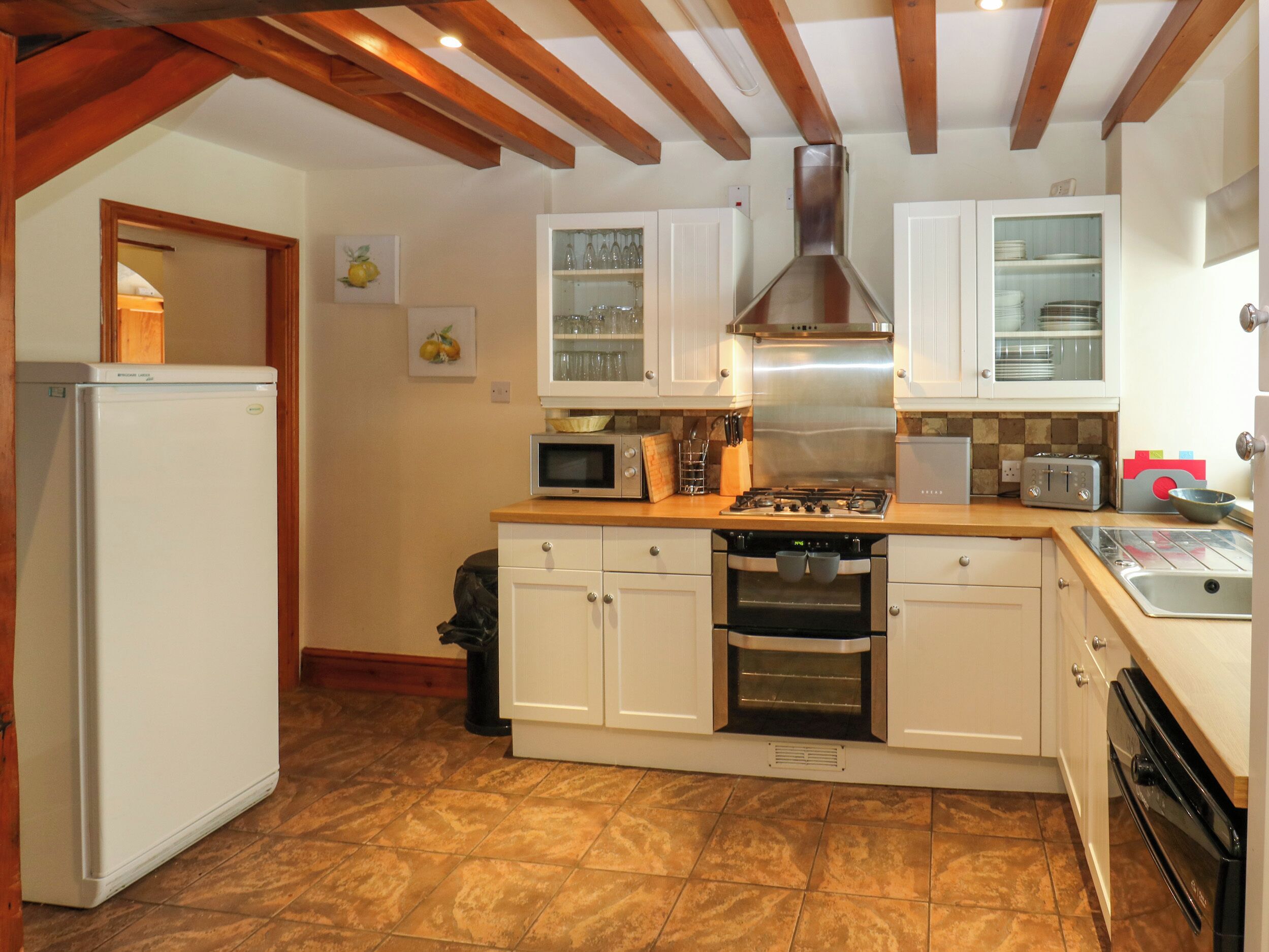 A kitchen with white cabinets, a microwave, a stove, and a refrigerator.