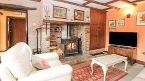A cozy living room with a fireplace, a television, and a comfortable seating area. - Loanview (Cornhill on Tweed)