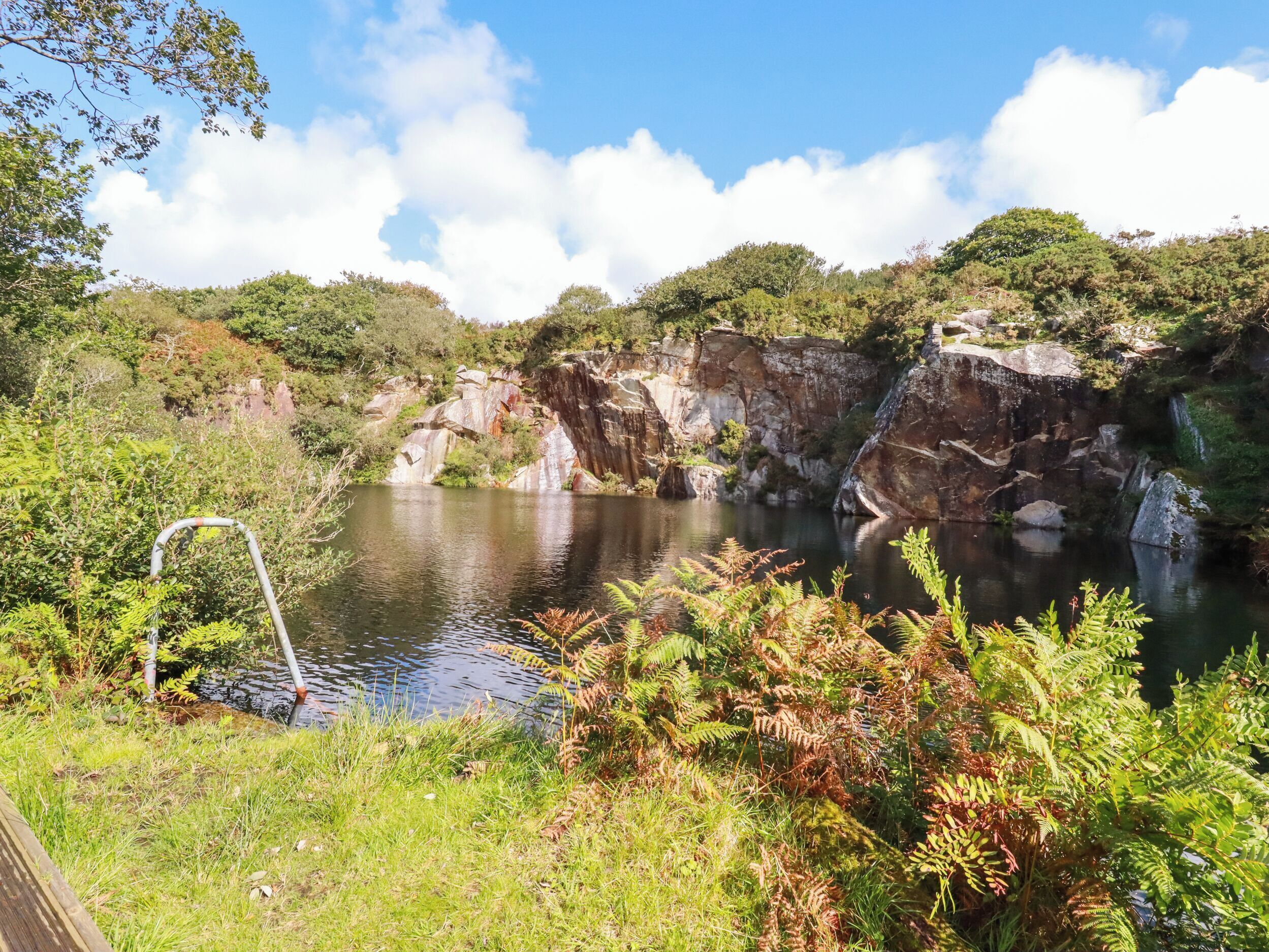 Un paysage naturel comprenant une rivière, des falaises rocheuses et une végétation luxuriante.