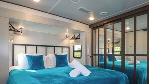 A hotel room with a large bed, a window, and a sliding door. - Tickeydoo, Tor Down Quarry (Bodmin)