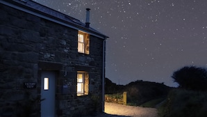A stone building with two lit windows and a sign reading "Victory View." - Victory View (Penzance)