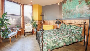 A room with a bed, a chair, a small table, and a potted plant. - Mermaid's Rest (Newquay)