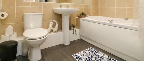 Un baño con inodoro, lavamanos y bañera.