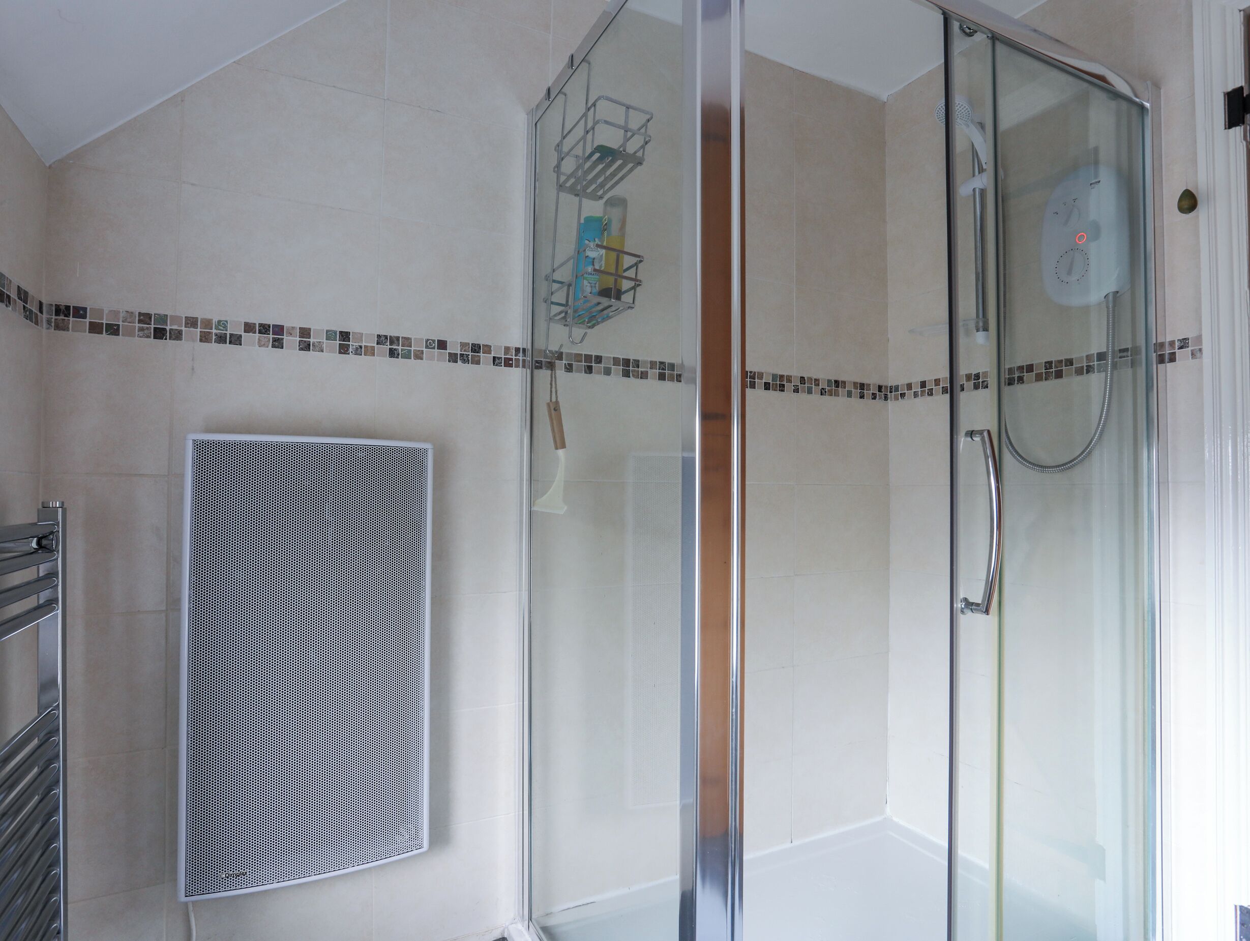 Een moderne badkamer met een douchecabine van glas, een ventilatie-unit aan de muur en een betegelde douchehoek.