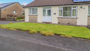 A single-story house with a tiled roof, a visible number '41' on the door, and a solar panel on the roof. - Craggy View (Kendal)