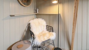 A room with a round mirror, a hanging basket, a fluffy chair, a lamp, and a wooden ladder. - Rowan Cottage - Fold Yards (Matlock)