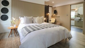A bedroom with a large bed, a bedside table with a lamp, a chair, and a mirror. - Rowan Cottage - Fold Yards (Matlock)