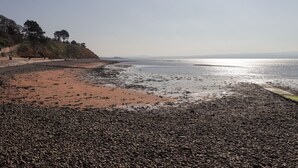 A pebbly beach with a clear sky and distant hills. - Fuchsia Cottage (Fortrose)