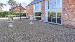A two-story brick building with large windows and a gravel driveway. - Heron's Den (Horncastle)