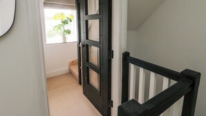 Eine Treppe mit schwarzer Geländer und einer Tür mit Glasverkleidungen.