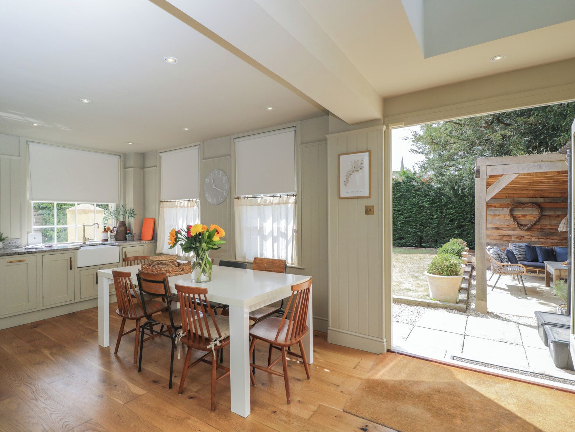 A spacious kitchen with a dining area, wooden flooring, and a view of the garden.
