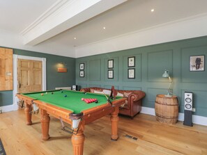 A pool table with balls, a sofa, a wooden door, and framed pictures on the wall. - Cotswold House (Moreton-in-Marsh)