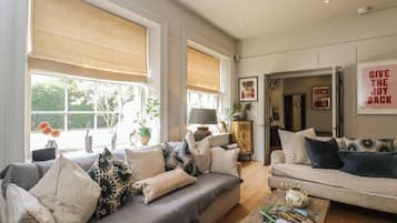 A spacious living room with two sofas, a coffee table, and a bookshelf.