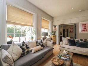 A spacious living room with two sofas, a coffee table, and a bookshelf. - Cotswold House (Moreton-in-Marsh)