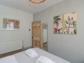 A bedroom with a bed, a wall-mounted mirror, and two framed pictures. - Cotswold House (Moreton-in-Marsh)